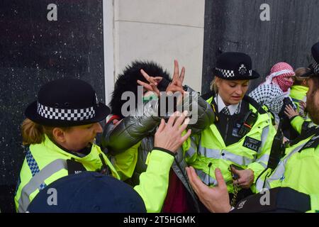 Londra, Regno Unito. 4 novembre 2023. Gli agenti di polizia arrestano un manifestante pro-Palestina a Piccadilly Circus. Un gruppo di manifestanti ha marciato nel centro di Londra e si è Unito a decine di migliaia di persone per una manifestazione a Trafalgar Square chiedendo un cessate il fuoco e in solidarietà con la Palestina mentre la guerra Israele-Hamas si intensifica. Foto Stock