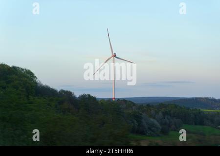 Le turbine eoliche si innalzano sopra la foresta contro un cielo nuvoloso. Foto Stock