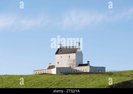 Il Castello di Corgarff, la Casa medievale imbiancata della Torre su una remota collina nelle Highlands scozzesi, situata contro un cielo blu in tarda estate Foto Stock