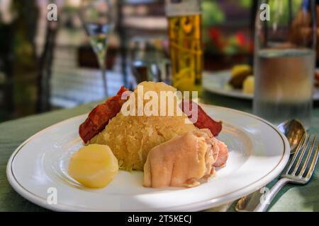 Garnie choucroute tradizionale alsaciano, crauti con salsicce, nocciolo di maiale, altre carni e patate in un ristorante winstub a Strasburgo, Francia Foto Stock