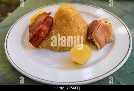 Garnie choucroute tradizionale alsaciano, crauti con salsicce, nocciolo di maiale, altre carni e patate in un ristorante winstub a Strasburgo, Francia Foto Stock