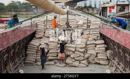 Operaio che scarica cemento dalla barca, questa immagine è stata catturata il 29 maggio 2022, da Amen Bazar, Bangladesh Foto Stock