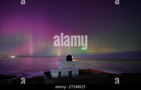 L'aurora boreale, nota anche come aurora boreale, appare sopra il faro di Bamburgh, nel Northumberland, sulla costa nord-orientale dell'Inghilterra. L'aurora potrebbe essere vista in tutto il Regno Unito domenica. Data foto: Domenica 5 novembre 2023. Foto Stock