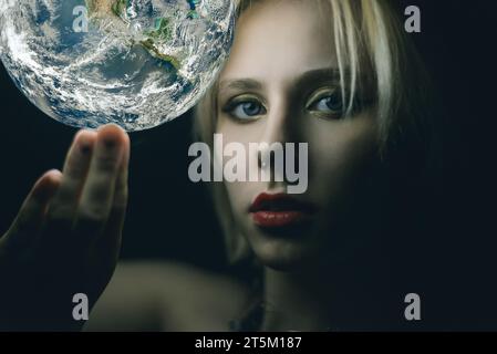 La donna tiene la Terra in mano. Elementi di questa immagine forniti dalla NASA Foto Stock