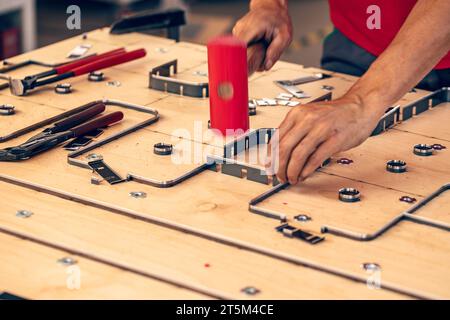 Maestro professionista maschile che utilizza il martello mentre crea modelli creativi Foto Stock