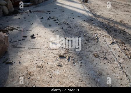 Le cartucce sparate dalle armi automatiche sono ancora a terra. Edifici carbonizzati e distrutti di Kibbutz Kfar Aza dopo un brutale attacco da parte di Foto Stock