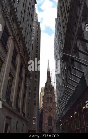 Un iconico edificio dell'orologio antico si erge alto, circondato da grattacieli moderni, sullo sfondo di un cielo americano blu vivo Foto Stock