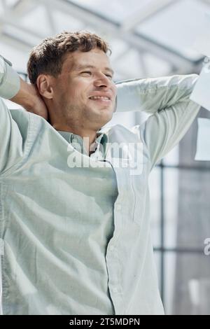 Uomo millenario calmo con gli occhiali sedersi rilassarsi a casa ufficio sul posto di lavoro fare pisolino o sognare ad occhi aperti Foto Stock