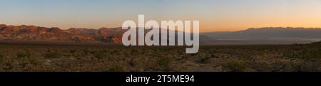 Una vista panoramica della desolata Valle della morte ad ovest degli appartamenti di Mesquite, nel campeggio Emigrant, all'alba, toni arancioni nel cielo. Picco Grapevine. Foto Stock