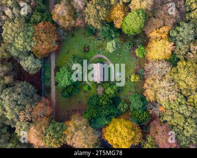 Vista aerea dall'alto verso il basso di una piccola Cappella e del cimitero nei colori autunnali Foto Stock