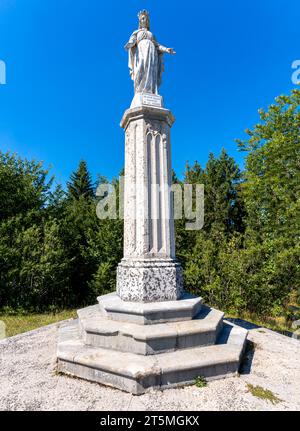 Les Bouchoux, Francia - 09 02 2021: Veduta della statua della vergine sulle colline Foto Stock
