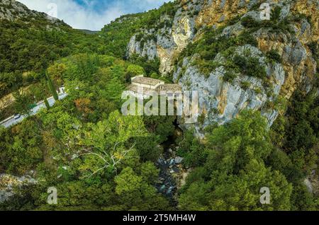 Veduta aerea dell'eremo di San Venanzio sospeso tra pareti di roccia sul letto dell'Aterno e la valle. Raiano, Abruzzo Foto Stock