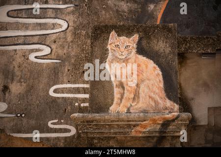 Ginger Cat seduto. Arte di strada disegnata sul muro di una casa nella città vecchia di takua pa Takua Pa Thailandia, Phang Nga 2 marzo 2023 Foto Stock