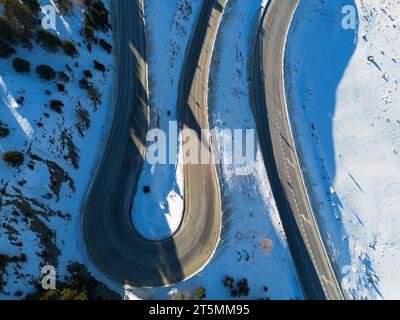 Foto aerea di una strada di montagna innevata di Andorra che si snoda attraverso W. Foto Stock