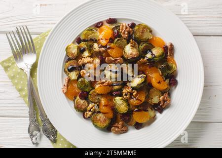 Cavoletti di Bruxelles di mirtilli rossi fatti in casa, insalata di mandarino con condimento balsamico da vicino in un piatto sul tavolo. Vista superiore orizzontale dall'alto Foto Stock