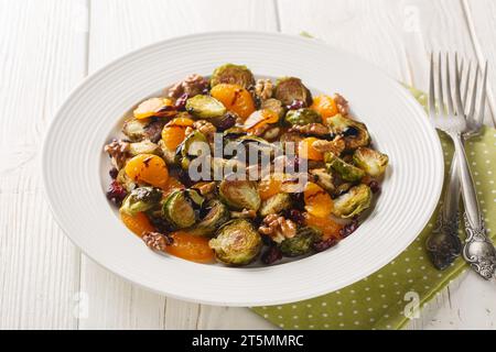 Cavoletti di Bruxelles di mirtilli rossi fatti in casa, insalata di mandarino con condimento balsamico da vicino in un piatto sul tavolo. Orizzontale Foto Stock