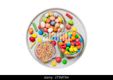 caramelle tonde di colore diverso in ciotola e vasetti. Vista dall'alto di una grande varietà di dolci e caramelle con spazio copia. Foto Stock