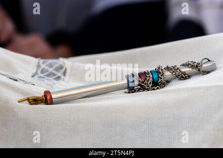 Un puntatore decorativo d'argento o yad, usato per aiutare il lettore della Torah o della bibbia ebraica, giace su un panno prima del servizio di preghiera mattutino. Foto Stock