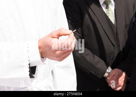 Uno sposo mostra l'anello che ha acquistato per la sua sposa durante lo scambio o la cerimonia degli anelli di un matrimonio ebraico. Foto Stock