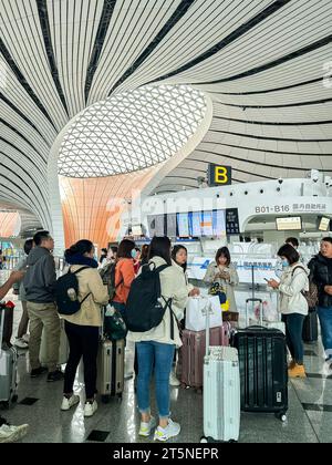 Pechino, Cina, gente numerosa, che viaggia all'interno, vista dell'aeroporto internazionale Daxing di Pechino, hall, terminal, architettura moderna (credito architetto: Zaha Hadid) Foto Stock