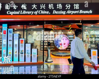 Pechino, Cina, uomo che cammina davanti, vista interna dell'aeroporto internazionale di Pechino Daxing, all'interno della libreria cinese, 'Biblioteca della capitale della Cina', insegna Foto Stock