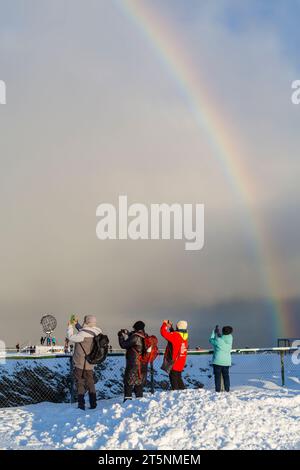 I visitatori fotografano l'incredibile arcobaleno sopra la struttura del monumento Globe, Capo Nord, Nordkapp, Norvegia, Scandinavia, Europa a ottobre Foto Stock