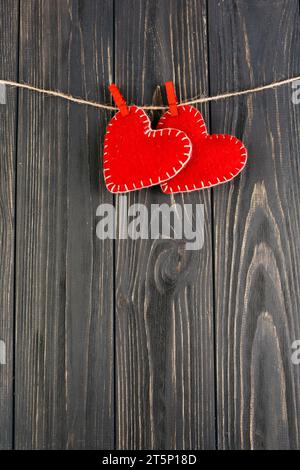 Giocattoli in feltro a forma di cuore rossi con cordoncino appeso Foto Stock