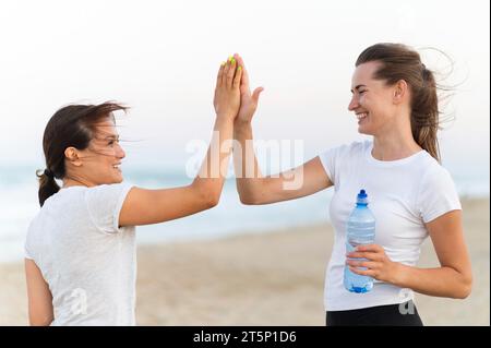 Vista laterale, due donne che figgiano ciascuna Foto Stock