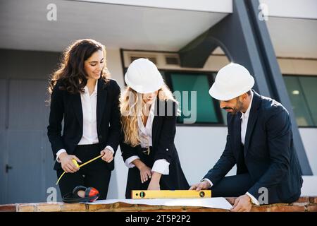 Architetti che indossano caschi con un piano Foto Stock