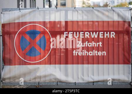 Dresda, Germania. 6 novembre 2023. Uno striscione con l'iscrizione 'Feuerwehr Zufahrt' e un cartello 'Parkverbot' appeso ad un cancello d'ingresso nell'area industriale su Straße E. Credit: Robert Michael/dpa/Alamy Live News Foto Stock