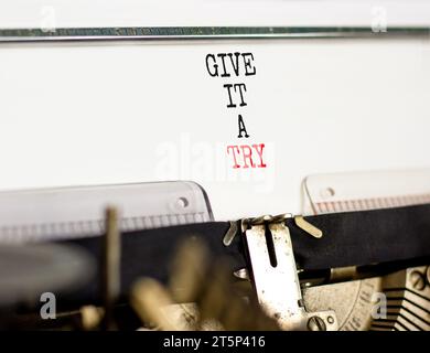 Dategli un simbolo di prova. Parola concettuale prova a scrivere la vecchia macchina da scrivere retrò. Splendido sfondo di carta bianca. Affari, provaci Foto Stock