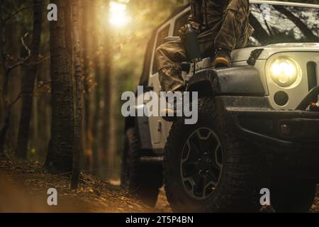 Camouflage con Hunter che si prende una breve pausa caffè durante la guida fuoristrada Foto Stock