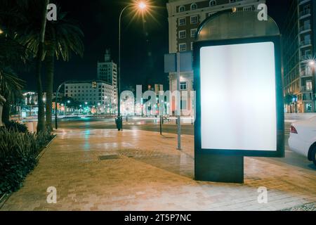 Percorso pubblicitario vuoto con semafori sfocati di notte Foto Stock