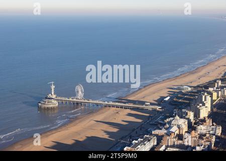 Molo Dutch Scheveningen con ruota panoramica sulla costa olandese con lunghe ombre Kurhaus sulla spiaggia Foto Stock