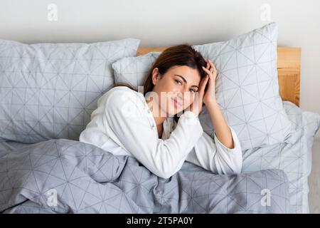 Letto donna sonnolento con pigiama e vista dall'alto Foto Stock