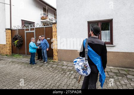 Resoconto locale di un fratello Roland dopo aver terminato il suo apprendistato, è accompagnato da amici dal cartello del villaggio alla casa dei suoi genitori e dall'avie Foto Stock