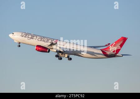 Un Airbus A330-343 Virgin Atlantic, registrazione G-VLUVH (Lady Love) in direzione ovest fuori dall'aeroporto di Manchester (MAN) in una soleggiata serata autunnale Foto Stock
