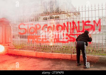 Milano, Milano, Italia. 4 novembre 2023. Mentre la processione organizzata per chiedere una fermata al genocidio del popolo palestinese si riversa nelle strade del centro di Milano, una ragazza scrive, bagnata dai fumi di una granata fumogena "ferma colonialismo, libera Palestina" (Credit Image: © Rachele Cipollini/ZUMA Press Wire) SOLO USO EDITORIALE! Non per USO commerciale! Foto Stock