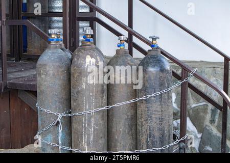 Primo piano di bombole in acciaio con gas compresso - argon, anidride carbonica o ossigeno per la saldatura, all'aperto Foto Stock