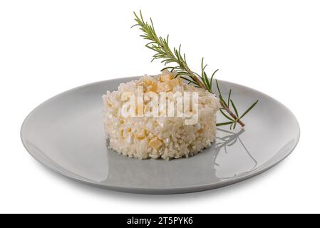 Riso condito con formaggio fresco e pezzetti di parmigiano e rosmarino in piatto isolato su bianco con percorso di ritaglio incluso Foto Stock