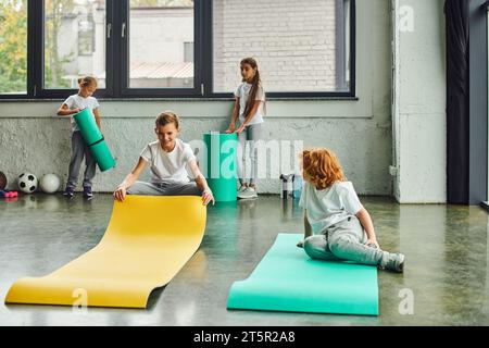 bambini preadolescenti allegri in abbigliamento sportivo che si aprono in palestra, allenamento, sport per bambini Foto Stock