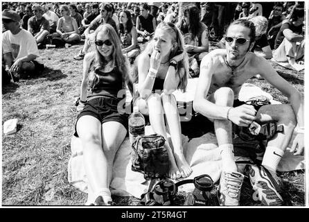 BRITPOP and ROCK FANS, READING FESTIVAL, 1998: I giovani amici condividono un momento di relax sul palco principale. Una scena dal sito e la folla nell'area dell'arena Main Stage al Reading Festival 1998 il 28-30 agosto 1998 a Reading, Inghilterra Regno Unito. Foto: Rob Watkins Foto Stock