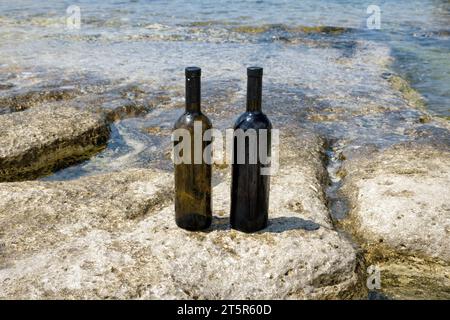 Due bottiglie di vino sulla costa rocciosa del Mar Caspio. Foto Stock