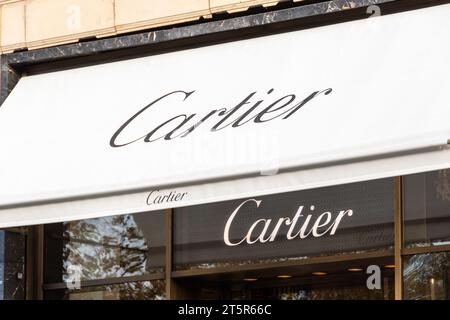 Tendalino e cartello della boutique Cartier in Avenue des Champs-Elysées. Cartier è un'azienda francese specializzata in gioielli, orologi e beni di lusso Foto Stock