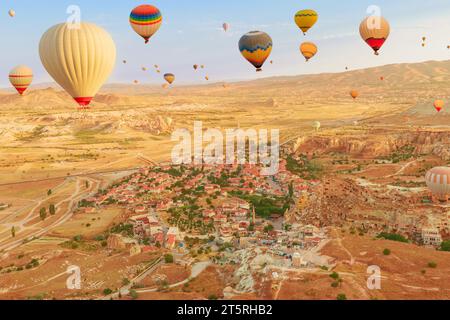 Mongolfiere nel vasto skyline della Cappadocia. Le brillanti sfumature dei palloncini catturano la luce del giorno, creando un'incantevole illuminazione sul surreale Foto Stock