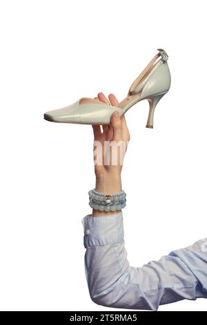 Una mano femminile che regge un'elegante scarpa estiva blu a punta quadrata, isolata su uno sfondo bianco. Scarpe eleganti in mostra a mano. Blog di moda. Uscita Foto Stock