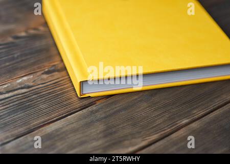 Elegante libro con copertina rigida in pelle testurizzata isolato su uno sfondo di legno. Vista prospettica, primo piano, ritagliata. Album fotografico, album fotografico, diario, plann Foto Stock