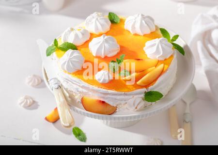 Meringa di pesca fatta in casa servita come dessert primaverile. Meringa di pesca a base di frutta e panna. Foto Stock