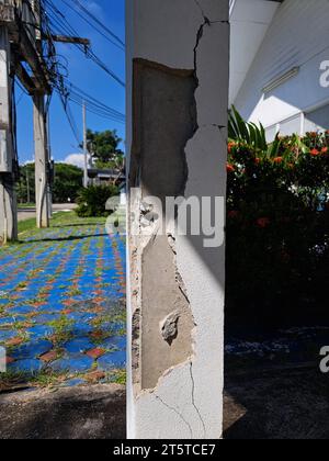 Incrinature nei pilastri di costruzione danneggiati. Pilastro di cemento incrinato di una vecchia casa. Fratture profonde e chiare, sulla superficie anteriore di un vecchio montante di cemento. Foto Stock