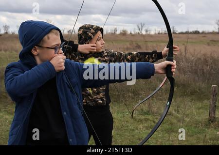 Zaporizhzhia, Ucraina. 5 novembre 2023. I giovani ragazzi praticano il tiro con l'arco nel club di tiro con l'arco dei cosacchi "Bayda". La guerra tra Israele e Gaza sta "togliendo l'attenzione” dal conflitto in Ucraina, ha ammesso il presidente del paese Volodymyr Zelensky. E ha negato che i combattimenti in Ucraina avessero raggiunto uno stallo, nonostante una recente valutazione in tal senso da parte del generale militare più importante del paese. La controffensiva dell'Ucraina nel sud ha finora fatto pochi progressi. Credito: SOPA Images Limited/Alamy Live News Foto Stock